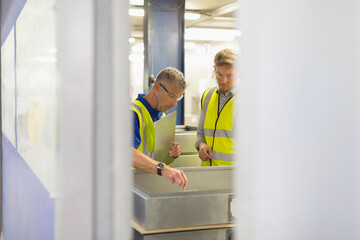 Wall Mural - Supervisor and worker inspecting pieces in steel factory