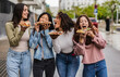 © PintoArt - multiracial female friends eating street food in the city, tasty pizza,