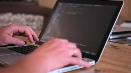 Male hands writes program code on laptop close up, IT specialist, programmer work in home office. Mobile developer working in computer at home. Distant workday concept. 