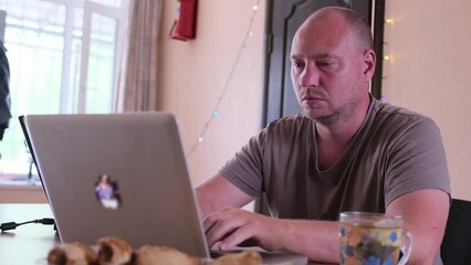 Freelancer, designer man working by typing on keyboard and look at monitor, in cozy home environment, freelancer and work at home concept