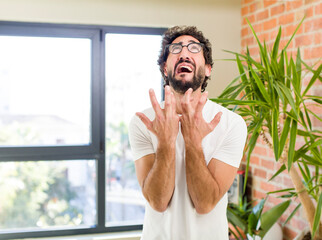 Wall Mural - young adult crazy man with expressive pose at a modern house interior