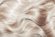 © Vera - Blond hair close-up as a background. Women's long blonde hair. Beautifully styled wavy shiny curls. Hair coloring. Hairdressing procedures, extension. White hair