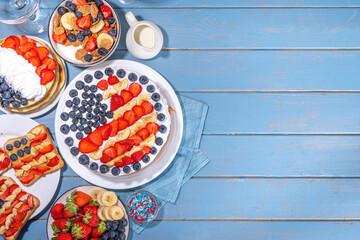 Fourth of July, Patriotic Independence day desserts.  4th of July sweet brunch food and snacks - toast sandwiches, flakes with berries, cake, pancakes, champagne with glasses, holiday decor, flags 