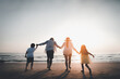 © Garun Studios - Happy Asian family consisting of father, mother, Son and daughter having fun playing on the beach.