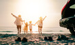 © Garun Studios - Asian family vacation holiday, Happy family running on the beach in the sunset.Happy family is running into the sea.Back view of a happy family on a tropical beach and a car on the side.