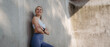 © Halfpoint - Portrait of young sporty woman in sportswear leaning agaist concrete wall in the city.
