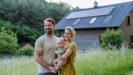 Wall Mural - Happy family near their house with solar panels. Alternative energy, saving resources and sustainable lifestyle concept.