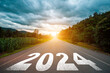 © Tarokmew - New year 2024 concept. Text 2024 written on the road in the middle of asphalt road with at sunset. Concept of planning, goal, challenge, new year resolution..