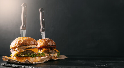 Poster - Two mouth-watering, delicious homemade burger used to chop beef. on the wooden table.