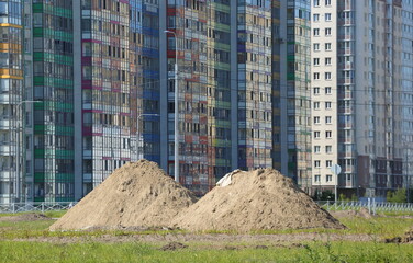 Two piles of sand near a new apartment building, Soyuzny Prospekt, Saint Petersburg, Russia, June 12, 2023