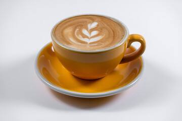 hot coffee latte with foam in yellow ceramic cup on white background