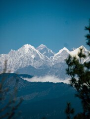 Wall Mural - Vertical shot of the Himalayas peaks covered in snow with a blue sky in the background, in Asia