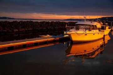 Sticker - Port with a parked boat and a sea in the background during sunset