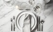  a table set with a white plate, silverware, and silverware on a marble table top with a white napkin and silverware.  generative ai