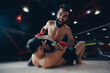 © Parilov - Boxers Aggressive fighter in MMA tournament in ring cargo octagon, dark background spot light