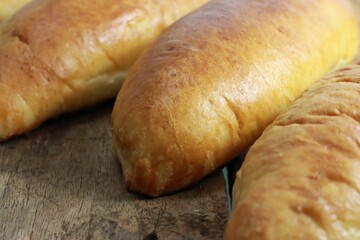 Canvas Print - Horizontal close-up view of newly cooked fish buns on a wooden background