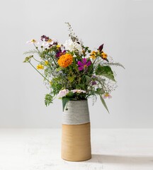 Canvas Print - Vertical shot of a bouquet of wild flowers in a vase isolated on a white background