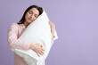 © Pixel-Shot - Young woman with soft pillow on lilac background