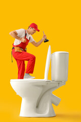 Canvas Print - Young plumber with plunger and toilet bowl on yellow background