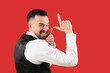 © Pixel-Shot - Handsome man showing loser gesture on red background