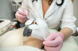 Beautician applying gauze bandage before paraffin face mask
