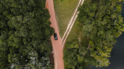 Sticker - Aerial view of a car driving on a dirty road in Florida wilderness