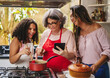 Avó, mãe e filha Brasilieiras na cozinha se divertindo enquanto preparam uma receita juntas para os dia das mães