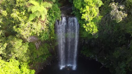 Wall Mural - Drone view of people swimming in the lake under the waterfall