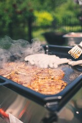 Poster - Shallow focus of bbq grill with meats cooking on them with blur trees in the garden