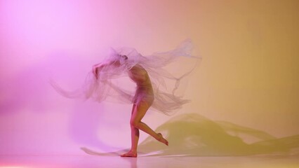 Wall Mural - Lightness. Graceful, attractive, young ballerina dancing with transparent veil against gradient pink yellow studio background in neon light. Concept of classical art, dance, beauty, inspiration