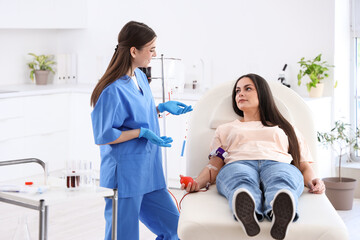 Wall Mural - Female blood donor talking with nurse in clinic