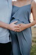 Vertical closeup shot of a husband and pregnant wife posing together at a maternity shoot
