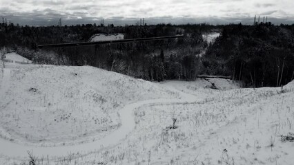 Poster - Drone footage of a snowy gorge above a dark mysterious snow covered forest