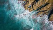 © Ervinfilms/Wirestock Creators - Top aerial view of blue waves crashing on the rocky coastline, summer seascape