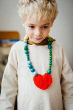 Boy Wearing An Handmade Necklace With Pearls And Felted Heart