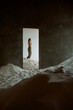 © Amor Burakova/Stocksy - Woman standing in a room full of sand