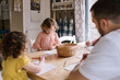 © Serena Burroughs/Stocksy - Happy family coloring togetehr at home