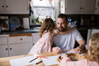 © Serena Burroughs/Stocksy - Smiling father coloring with his children at home at the kitchen table