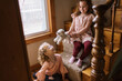 © Serena Burroughs/Stocksy - Sisters playing with toys on a staircase in their home