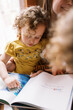 © Serena Burroughs/Stocksy - Mother and Daughter Reading together
