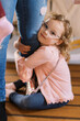© Serena Burroughs/Stocksy - little girl with glasses holding on to her mother's leg