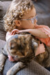 © Serena Burroughs/Stocksy - Girl petting her cat while sitting on couch
