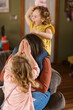 © Serena Burroughs/Stocksy - laughing mother playing with her wild toddler daughters in home