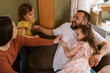 © Serena Burroughs/Stocksy - Family playing in living room together