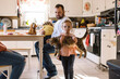 © Serena Burroughs/Stocksy - Cute happy toddler girl holding up her pet cat at home in kitchen