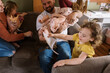 © Serena Burroughs/Stocksy - Family playing in living room together
