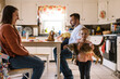 © Serena Burroughs/Stocksy - Cute happy toddler girl holding up her pet cat at home in kitchen