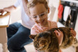 © Serena Burroughs/Stocksy - Cute happy toddler girl holding up her pet cat at home in kitchen