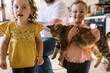 © Serena Burroughs/Stocksy - Happy twin sisters holding their pet cat in kitchen at home