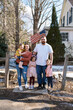 © Serena Burroughs/Stocksy - Happy family standing in front of home in spring outdoors